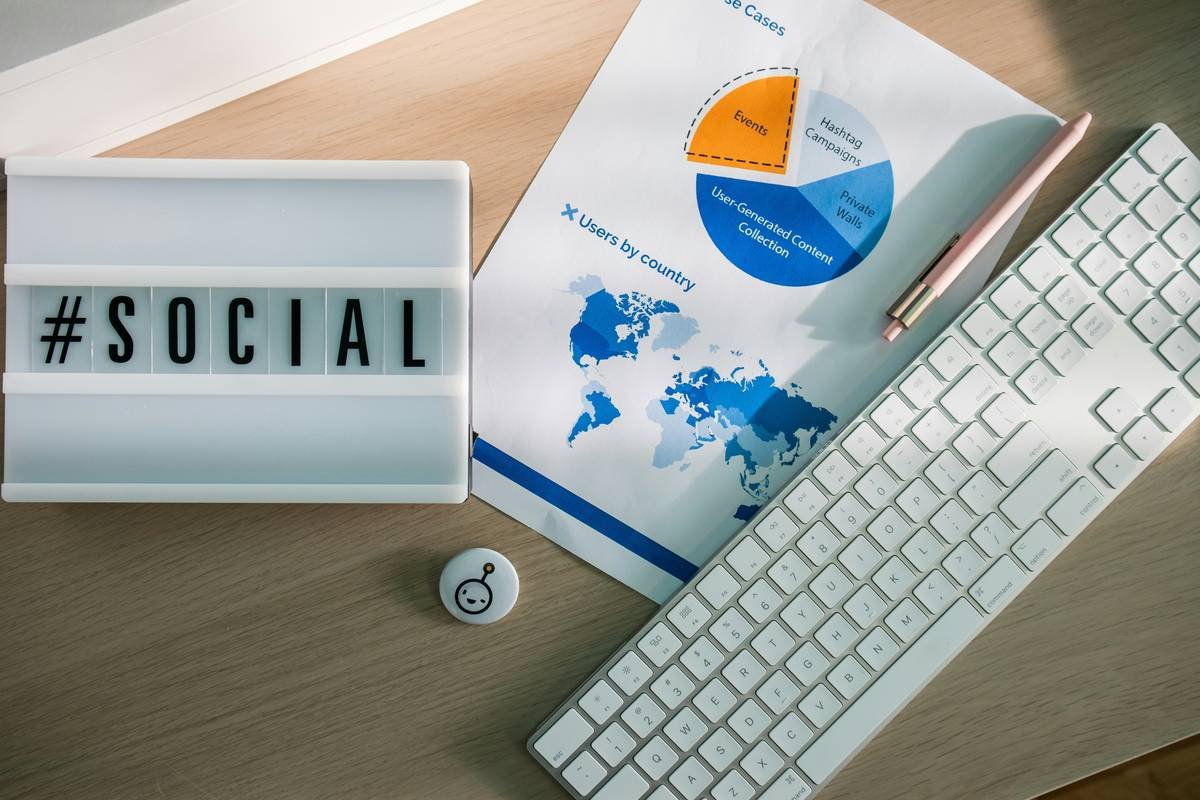 Desk with a light box with the hashtag #social, stationary elements and marketing stats
