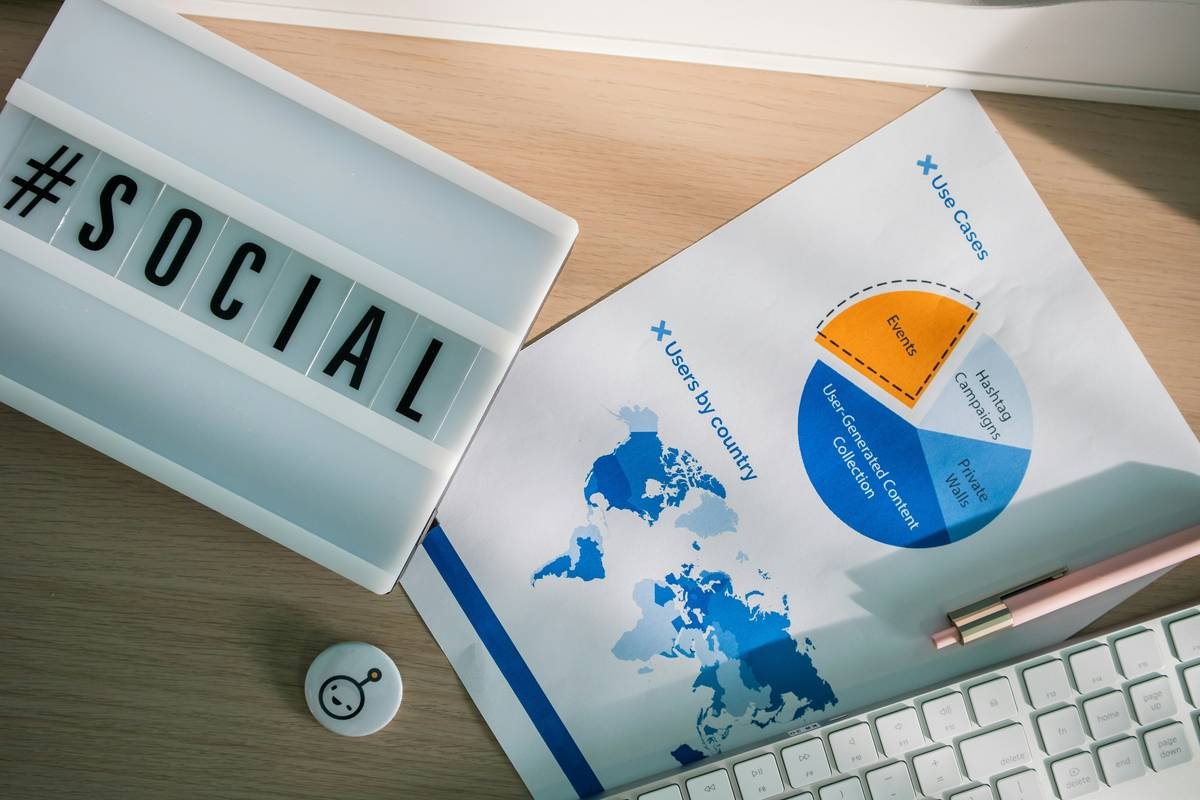 Desk with a light box with the hashtag #social, stationary elements and marketing stats