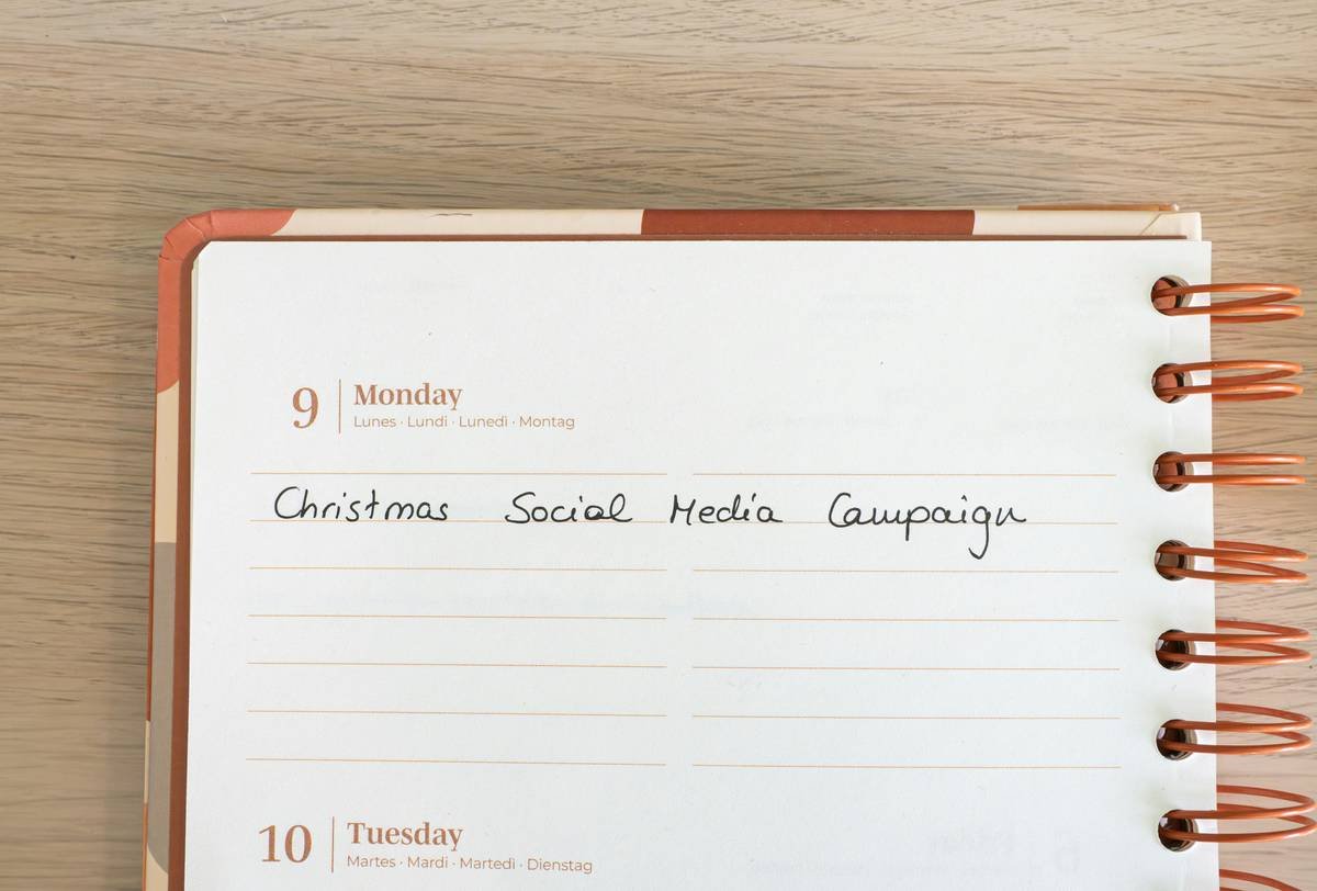 Desk with a planner with the concept Christmas Social Media Campaign